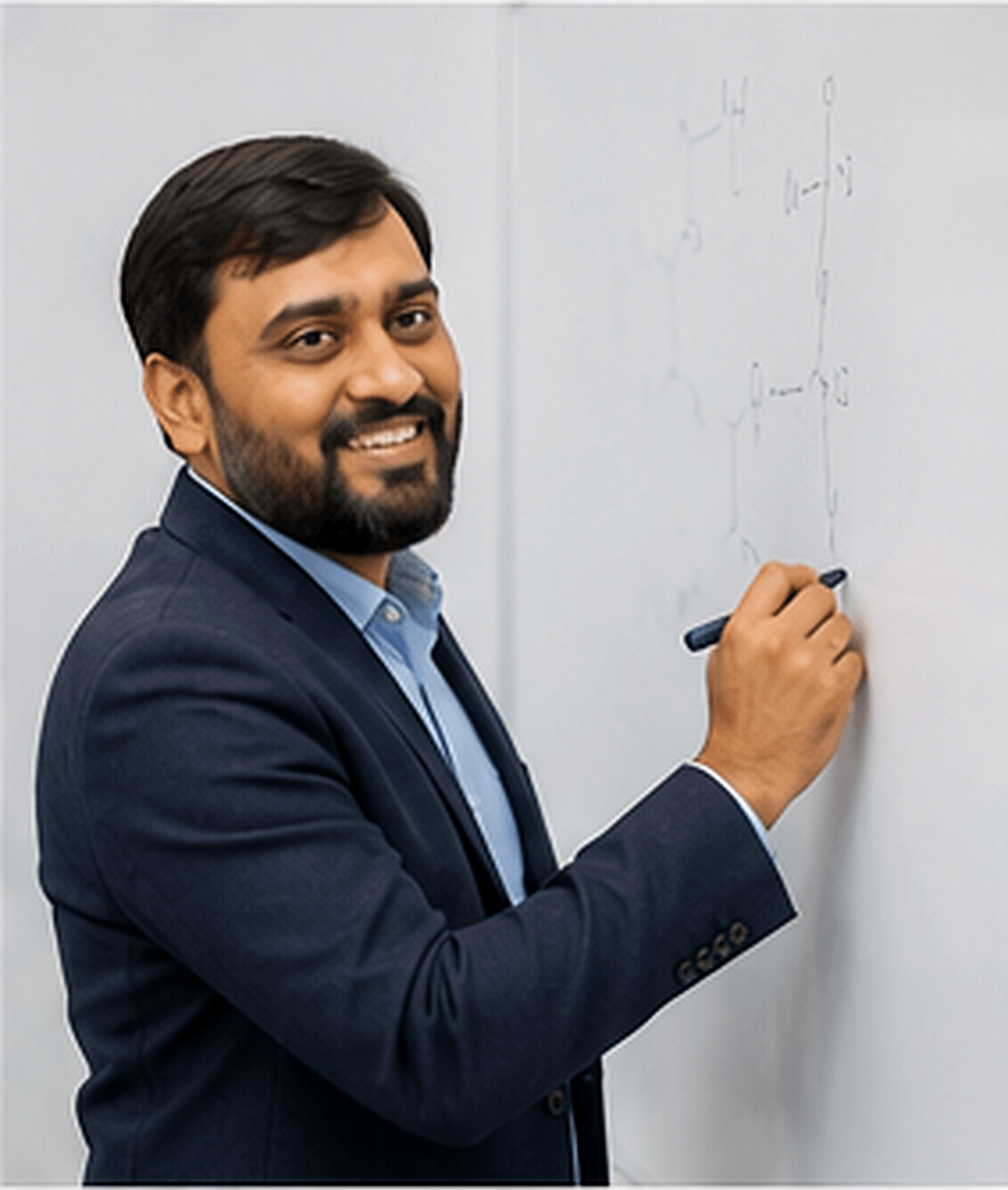 Dr. Yogesh Ajudiya writing organic chemistry structures on a whiteboard — the classroom in motion.